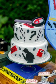 a birthday cake sitting on top of a table next to a blue sign and some other items