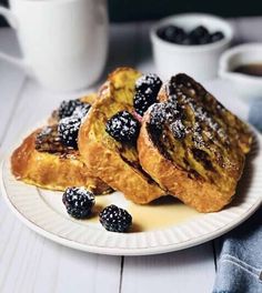 two pieces of french toast on a plate with berries