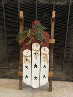 a wooden sled decorated with snowmen and pine cones