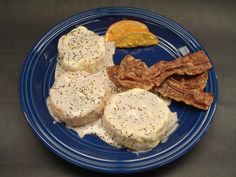 a blue plate topped with eggs, bacon and orange slices next to other food items