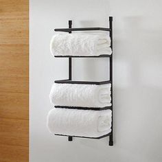 three white towels are hanging on a towel rack