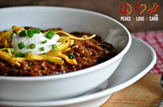 a white bowl filled with chili and sour cream