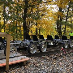 there are many motorcycles that are parked on the train tracks in the woods with people looking at them