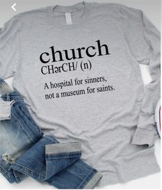 a t - shirt that says church on the front, and is next to jeans