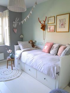 a bed room with a neatly made bed and pictures hanging on the wall above it