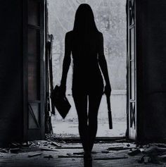 the silhouette of a woman walking out of an open door with her hand in her pocket