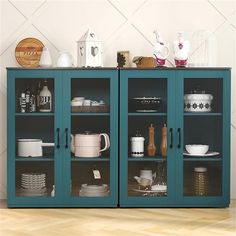 a blue cabinet filled with lots of dishes on top of a hard wood floor next to a white wall