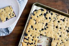 a pan filled with blueberry bars on top of a wooden table