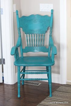 a blue chair sitting on top of a hard wood floor next to a white door