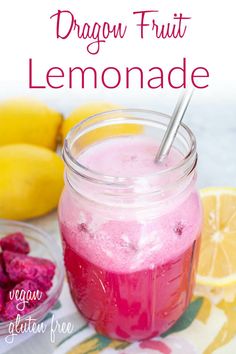 a jar filled with liquid next to lemons and raspberries