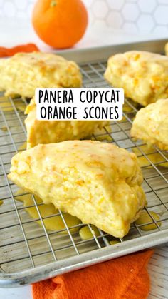 panera copycat orange scones on a cooling rack with an orange in the background