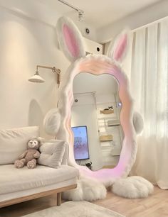 there is a mirror with bunny ears on it in the living room, next to a couch