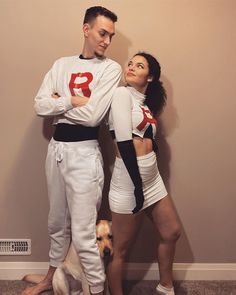 a man and woman in costume standing next to each other with a dog on the floor