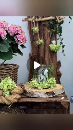 a vase filled with pink flowers sitting on top of a table next to a rope