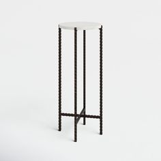 a black and white side table with an iron frame on the top, against a white background