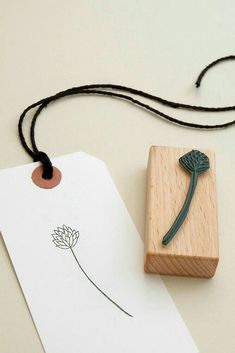 a rubber stamp with a flower on it next to a piece of paper and a string