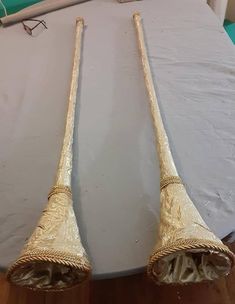 two large wooden sticks laying on top of a bed