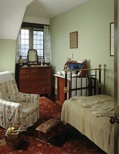 a bedroom with a bed, chair and dresser in it