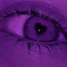 an eye with long eyelashes is shown in this purple photo, it appears to be looking into the distance