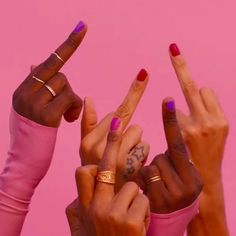 three women with their fingers in the shape of two peace signs, one holding up her hand