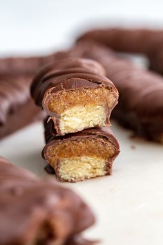 several pieces of chocolate covered doughnuts stacked on top of each other with one bite taken out