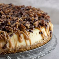 a cheesecake covered in nuts on a glass platter