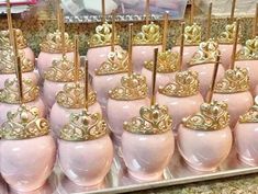 there are many pink vases with gold crowns on them