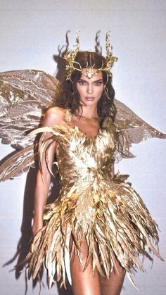 a woman in a gold costume with wings