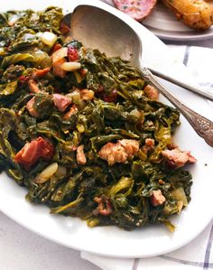 a white plate topped with collard greens and sausage