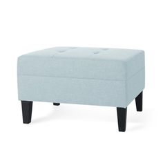 a light blue ottoman sitting on top of a white floor next to a black leg