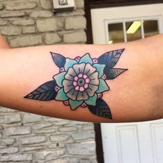 a woman's arm with a flower tattoo on it