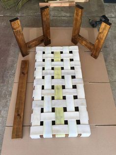 a piece of wood sitting on top of a cardboard box next to some pieces of tile