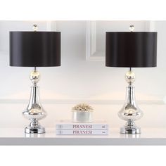 two silver lamps with black shades on them