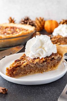 a slice of pecan pie on a white plate with whipped cream and cinnamon sticks