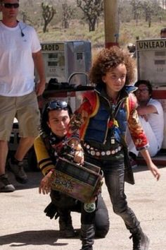 a young boy is trying to pull another kid on his skateboard