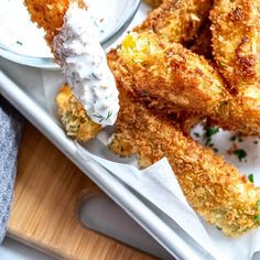 some fried food is on a tray with ranch dip and sour kraut sauce