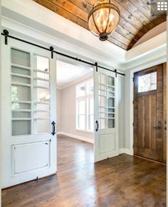 an empty room with wooden floors and white doors