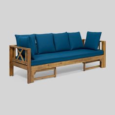 a wooden couch with blue cushions on it