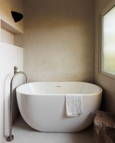 a large white bath tub sitting next to a window