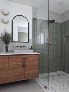 a bathroom with a sink, mirror and shower stall