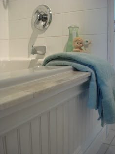 a white bath tub sitting next to a sink under a faucet