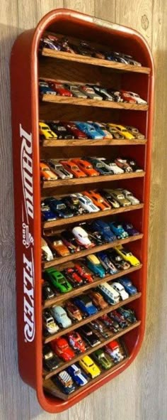 a red toy car storage rack on a wooden wall