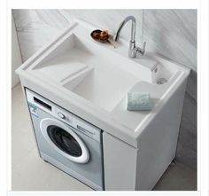 a white sink sitting next to a washer and dryer