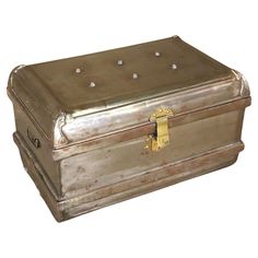 an old metal box with studs on the lid is shown against a white background