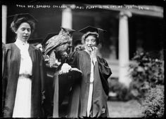 two women in graduation gowns holding an owl