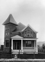 an old black and white photo of a house with a large porch on the front