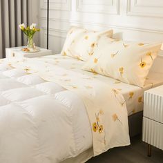 a bed with white sheets and yellow flowers on it