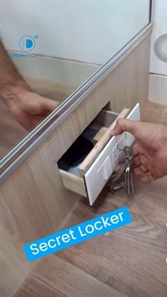 a person opening a drawer on the floor in front of a mirror that says secret locker