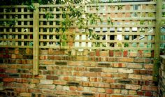 a brick wall with a wooden trellis on it