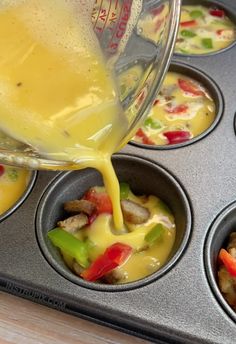 someone pouring dressing into a muffin tin filled with food